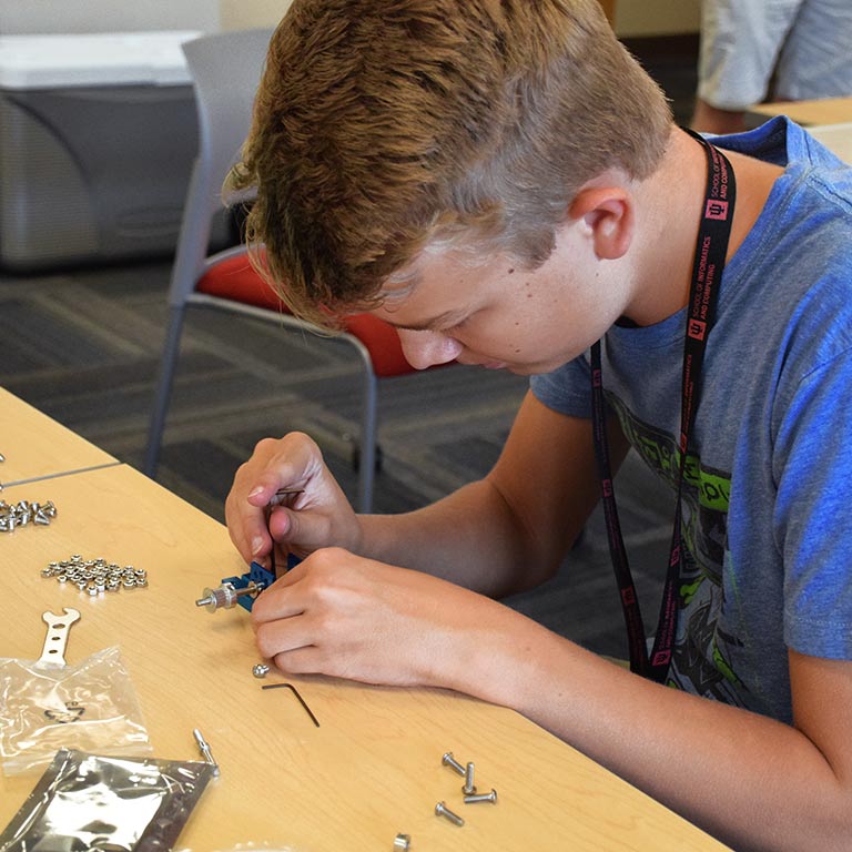 A student builds a device with tools during SICE Summer Camp.