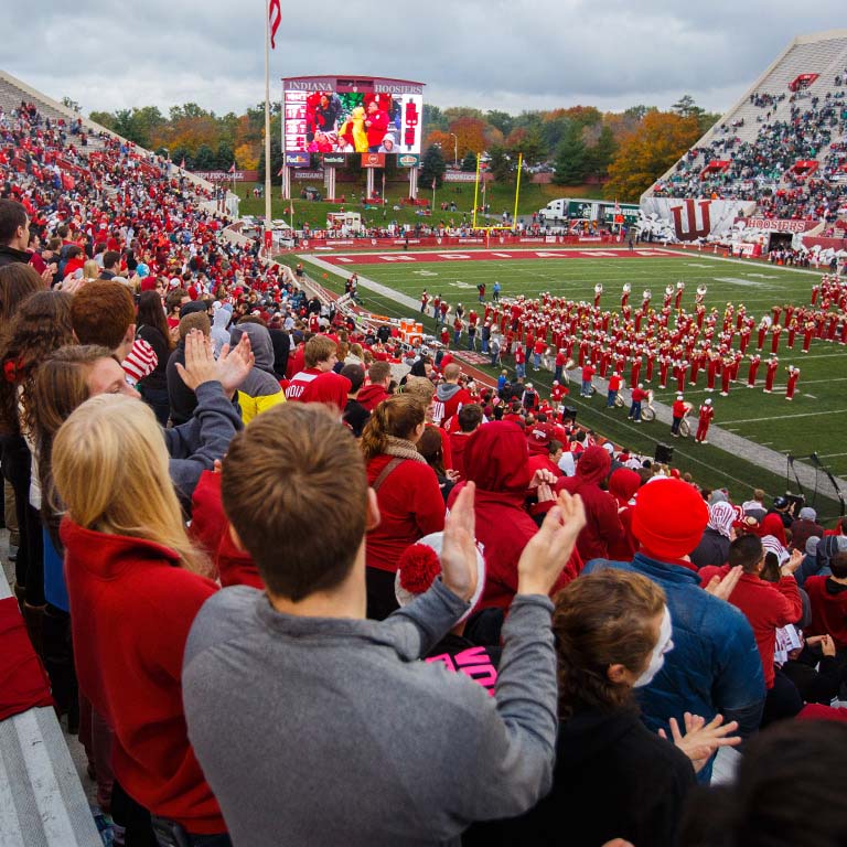 Students clap during the marching band's performance at Memorial Stadium.